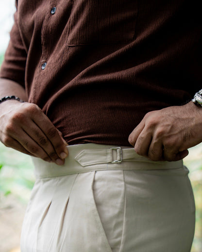Person wearing a brown camp collar shirt with 'Viero' logo and beige pants.